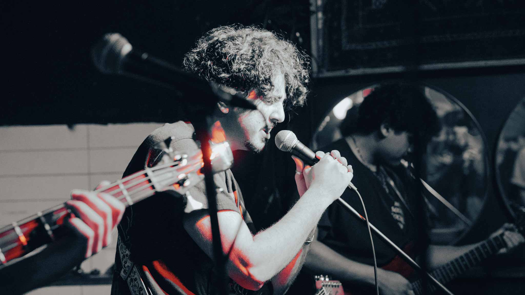 Vocalist singing with a bass neck crossing the foreground